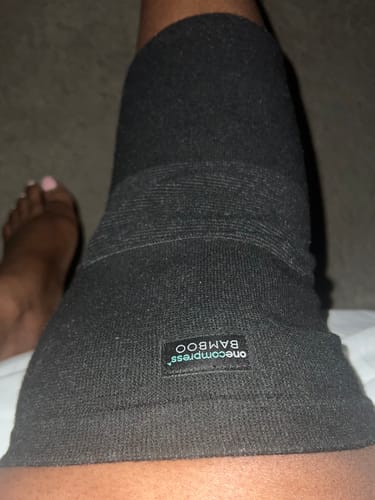 Close-up of a reviewer wearing the black Premium Bamboo Knee Sleeve on their leg.