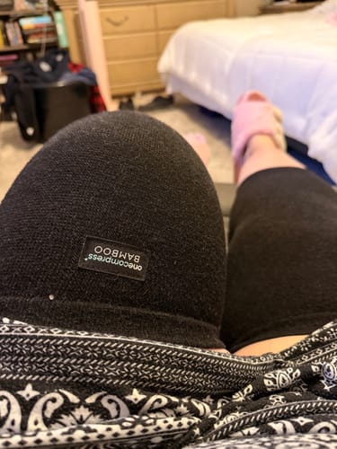Close-up of a customer wearing the black bamboo knee sleeve while resting their legs.