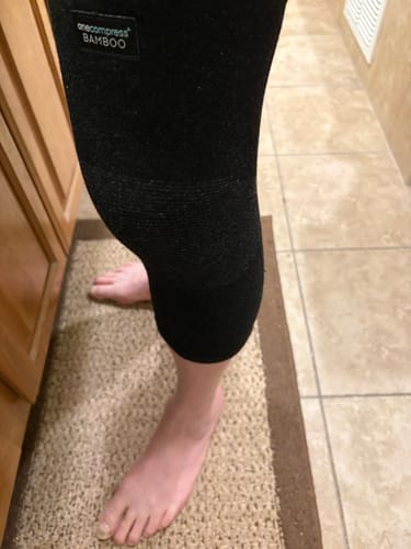 Reviewer's leg shown from the side wearing the black Premium Bamboo Knee Sleeve.